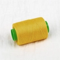 Single roll of high-quality yellow sewing thread wound on a green plastic spool - About 300 Meters / Golden Yellow