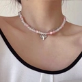 Collier de perles roses et blanches avec pendentif coeur argenté sur un mannequin - Rose et Blanc (JXJL21027)