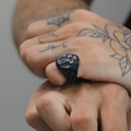 Close-up of vintage titanium steel ring with Celtic knot and cross relief pattern - US 6 / Black