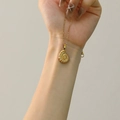 Macro view of 18k gold conch pendant showing intricate spiral texture and layered detail - Gold