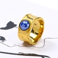 Detail of wide gold hammered ring featuring a vibrant round blue gemstone inlay - US 6 / Gold Blue