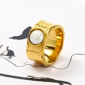 Close-up of wide textured gold ring with white pearl on minimalist art background - US 6 / Gold White Ceramic