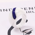 Close-up of white ceramic ring featuring a band of blue pavé-set rhinestones - US 6 / White With Blue Rhinestone