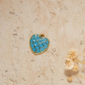 Macro detail of sky blue mermaid scale enamel heart pendant with golden plating - Blue