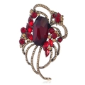 Detailed macro view of vintage gold alloy brooch with red crystals and rhinestone accents - Antique Gold Red