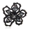 Macro detail of floral brooch featuring smoky grey faceted gems and black alloy petals - Antique Gold-Gray
