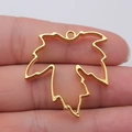Goldener Ahornblatt Hohlrahmen aus Metall für DIY Schmuckherstellung auf Fingerspitze - Helles Gold