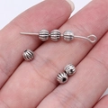 Silver pumpkin spacer beads for DIY jewelry making held in hand for size reference - Pumpkin Bead Style (B17094) / Antique Silver
