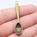 Vintage bronze spoon pendant DIY accessory shown on fingertip for scale comparison - Antique Bronze