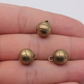 Three bronze volleyball charms held on fingertips to show the compact 14x11mm size - Antique Bronze
