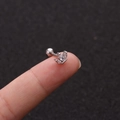 Detailaufnahme eines kleinen silbernen Kronen-Ohrsteckers mit Zirkonia am Finger - Kronen-Stil (No.14 Silber) / 1.2x6mm (Stabdicke x Länge)