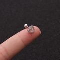 Makroansicht von Herz-Ohrstecker aus Edelstahl mit Zirkonia auf einer Fingerspitze - Herz Silber Strass Stil (No.4 Silber) / 1.2x6mm (Stabdicke x Länge)