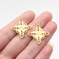 Golden Celtic knot pendant in polished alloy finish held by hand to show 28mm size - Bright Gold