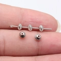 Five small silver carved cone beads for jewelry making shown on a finger for size - White K (D12287_W15-Z21)