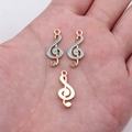 Himmelblaue und goldene G-Clef Musiknoten Anhänger mit Strasssteinen in der Hand - Himmelblau