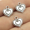 Tre ciondoli a cuore vintage in lega d'argento con bordo punteggiato tenuti in mano - 13x11mm / Argento antico