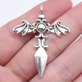 Gothic bat wing cross pendant in antique silver finish held to show scale and detail - Antique Silver