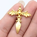 Golden gothic bat wing cross pendant with dagger element held in hand for scale - Bright Gold