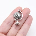 Antique silver globe pendant with detailed latitude lines and continent relief on white - Antique Silver