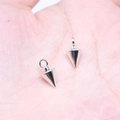 Pair of polished silver cone pendants with rings for DIY jewelry making held in palm - Antique Silver