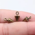 Miniature vintage brass cone charms for DIY jewelry shown on finger for scale - Antique Bronze