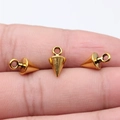 Three tiny gold cone spike charms for jewelry making held on a fingertip for scale - Antique Gold