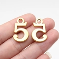 Golden number 5 charm pendants for DIY jewelry making shown in hand for scale - Antique Gold Number 5 (D10700)
