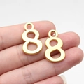 Golden number 8 metal pendant charms for DIY jewelry making shown in hand - Antique Gold Number 8 (D10703)