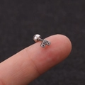 Macro-opname van een kleine zilveren stalen oorknop met drie zirkoonstenen en bolvormige sluiting - T-vorm Geometrische Zirconia Stijl (HSPJ1915-1#)