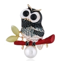 Detailed macro of golden owl brooch with enamel scales, black gems, and white pearl - KC Gold Black
