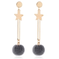 Close-up of dangling star moon earrings with dark grey faux fur pom-poms on white background - Gray