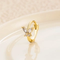 Gold huggie earring with zircon butterfly charm on a warm beige background - Gold White (Single)