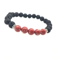 Detailaufnahme von schwarzen Lavasteinperlen und roten Türkisperlen auf Armband - Kaiserrot