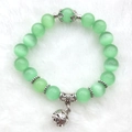 Pulsera de cuentas ojo de gato con colgante de bola hueca sobre superficie de felpa blanca - 10mm / Verde Fruta