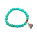 Detailed macro view of sky blue turquoise beads and vintage silver Om pendant on a bracelet - Blue Turquoise