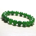Macro shot of polished green chalcedony beads on a minimalist light wood background - Green Chalcedony