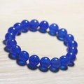 Deep blue chalcedony beaded bracelet with smooth translucent finish on wood background - Royal Blue Chalcedony
