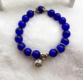 Detailed macro view of dark blue cat-eye beads and engraved silver metal pendant - 10mm / Blue