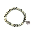 Macro detail of natural Dalmatian Jasper beads with silver Om charm on elastic bracelet - Dalmatian Jasper