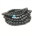 Ketting met 108 hematiet kralen en blauwe katteoog steen op witte achtergrond - 8mm Kattenoogsteen Stijl