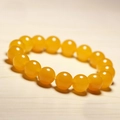 Macro shot of smooth round yellow chalcedony beads showing glossy oily texture - Yellow Chalcedony