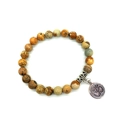 Macro shot of 8mm natural stone beads stretch bracelet with silver Om charm detail - Jasper