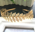 Dettaglio di un cerchietto con foglie di alloro dorate su cornice bianca - Oro
