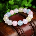 Close-up of colorful pastel chalcedony crystal beads on a vintage wooden display box - 6mm / Morganite
