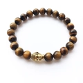 Tiger eye stone beaded bracelet with golden Buddha head charm on white background - Tiger Eye Stone Gold Buddha Style