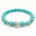 Blue turquoise bead bracelet with silver Buddha head charm and floral spacers - Turquoise