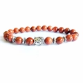 Ethnic stretch bracelet featuring red goldstone beads with a silver Buddha head accent - Gold Sandstone