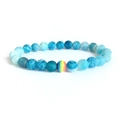 Blauwe matte stenen kralenarmband met regenboogkraal op witte achtergrond - Blauwe Verweerde Steen