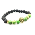 Bracelet en pierre de lave et perles de marbre avec tête de lion dorée sur fond blanc - Perles Vertes Et Tête de Lion Dorée