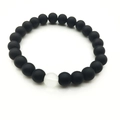 Primer plano de pulsera con cuentas negras mates de 8mm y una cuenta blanca translúcida - Negro mate
